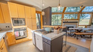 Una cocina moderna con armarios de madera, electrodomésticos de acero inoxidable y una isla grande.