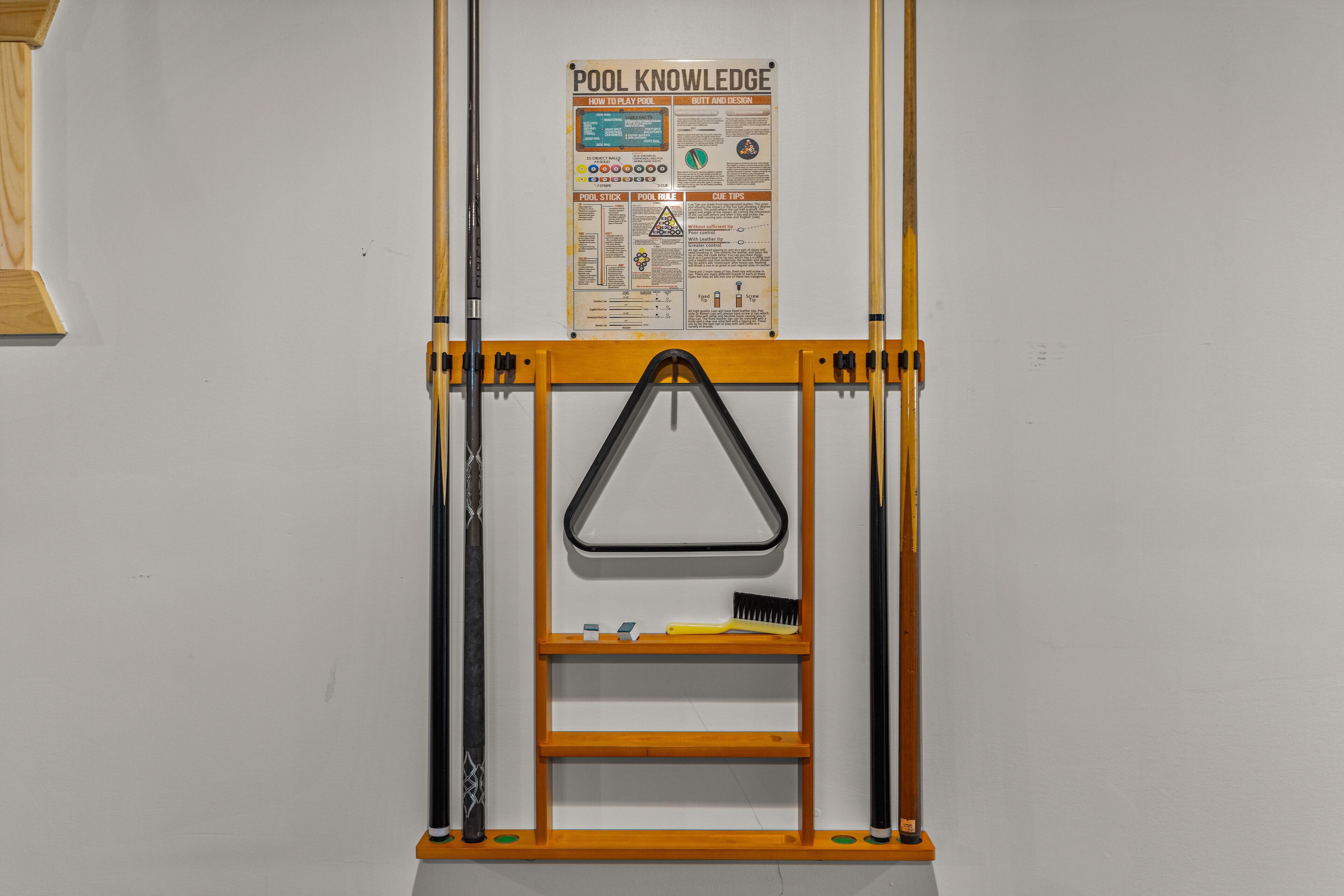 A pool knowledge poster with diagrams and text, a pool cue rack, and a ladder.