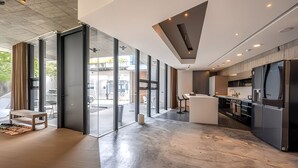 Une cuisine moderne dotée d’un îlot central, de grandes fenêtres et offrant une vue sur l’extérieur.