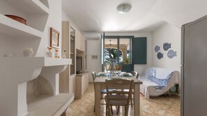 A dining area with a table set for four, a sofa, and a view of the outdoors.