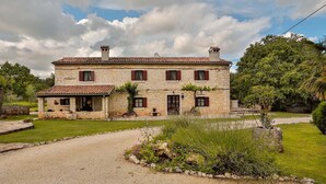 A two-story stone house with a gravel driveway and a garden. - Villa Edera in Sveti Kirin (Sveti Kirin)