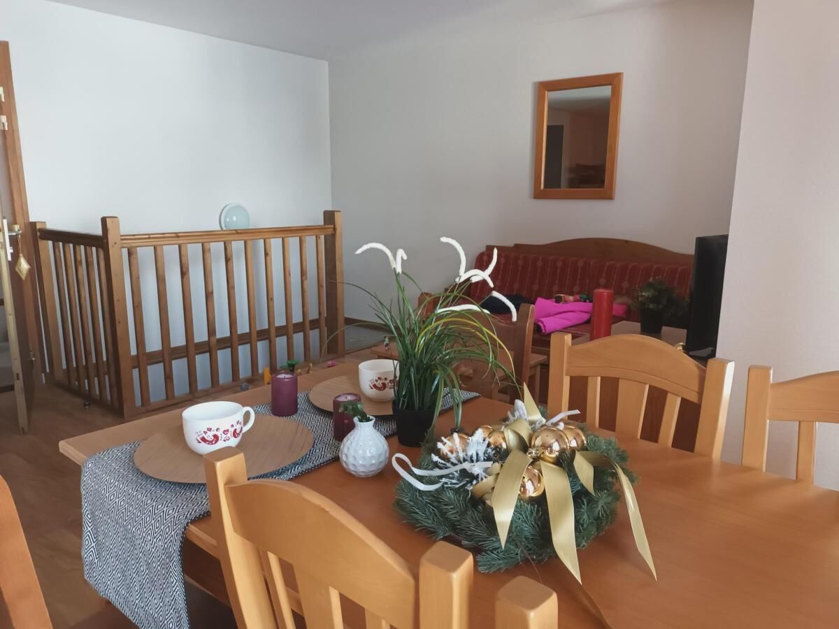 Un espace repas avec une table en bois, des chaises et une décoration de table festive.