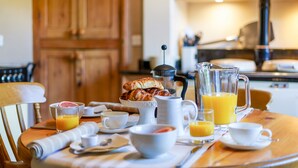 Une table de petit-déjeuner avec des croissants, du jus et du café.