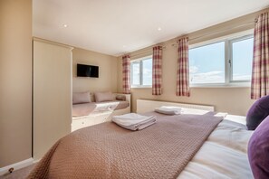 Cozy retreat with a large bed, bedside table, and flat-screen TV.