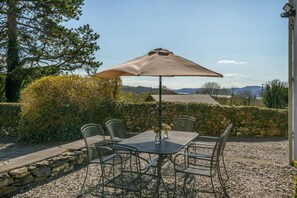 Enjoy a serene outdoor space with a table, chairs, and beautiful views of the surrounding hills.