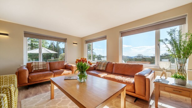 A spacious living room with a large window, a wooden coffee table, and a sofa set. - Orrest Head Cottage,  located on the footpath to the famous Orrest Head walk. Perfect for dog walks. (Windermere)