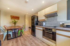 Enjoy cooking in this well-equipped kitchen with a central island, stainless steel appliances, and light-colored cabinetry.