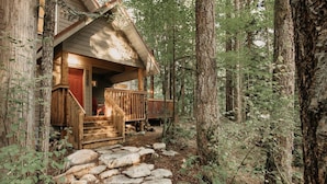 A cabin with a stone pathway leading to a wooden deck, surrounded by trees. - 40gs â Wifi - W/d â Hot Tub - Sleeps 8 3 Bedroom Cabin by RedAwning (Deming)