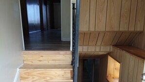 En trätrappa med ett metallräcke som leder upp till en liten plattform.