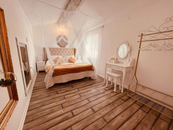 Classic bedroom with a bed, bedside table, and dresser featuring a mirror.