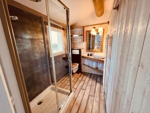 Bathroom features a glass-enclosed shower, sink, and mirror.