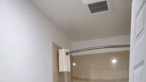 A bathroom with a toilet, a bathtub, and a shower curtain.