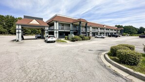 A multi-story hotel with a parking lot and a covered entrance.