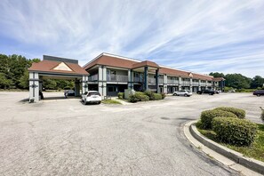 A multi-story hotel with a parking lot and a covered entrance.