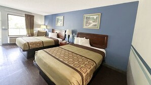 A hotel room with two beds, a large window with curtains, a wall-mounted air conditioner, and framed pictures.