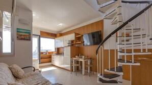A compact living space with a kitchenette, a dining area, and a staircase. - 3500 Panorama D`otranto by Barbarhouse (Otranto)