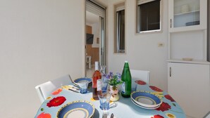 A dining table with floral tablecloth, plates, glasses, and a bottle. - 3500 Panorama D`otranto by Barbarhouse (Otranto)
