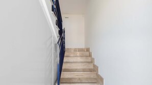 A staircase with beige steps and a blue handrail, leading to a white door at the top. - 3402 Casa Petrachi - PT by Barbarhouse (Melendugno)