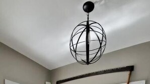 Una cocina moderna con una isla central, una zona de comedor con sillas y un ventanal con paneles de vidrio esmerilado.