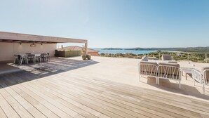 A wooden deck with outdoor furniture, a covered seating area, and a scenic view of the coastline. - Villa de Prestige 460m2, Pinarello, Magnifique vue Mer, Piscine Chauffée (Porto-Vecchio)