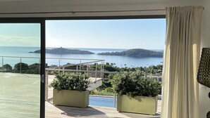 A balcony with a view of the sea and islands, two potted plants, and a decorative lamp. - Villa de Prestige 460m2, Pinarello, Magnifique vue Mer, Piscine Chauffée (Porto-Vecchio)