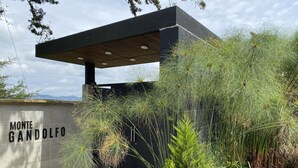 Een moderne gebouw ingang met een betonnen muur waarop 