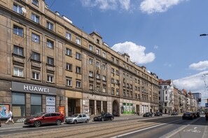 Un immeuble à plusieurs étages dont le rez-de-chaussée abrite un magasin Huawei.