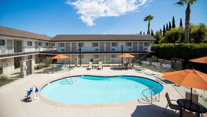 Ein Hotel mit Pool, Außenbereich und einem zweistöckigen Gebäude.