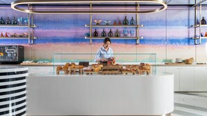 A modern bakery counter with pastries and a woman preparing food. - Maqo Changsha  (Changsha)