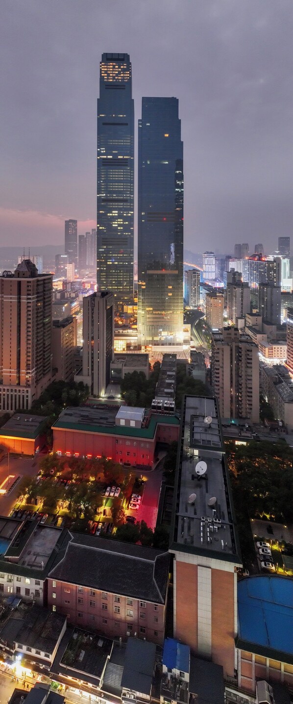 A cityscape with modern high-rise buildings, a parking area, and a clock tower. - Maqo Changsha  (Changsha)