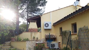 A residential building with a stone pathway, a brick chimney, and a satellite dish. - Villa Rénovée, à 5 Minutes du Centre et D'un Supermarché (Cogolin)