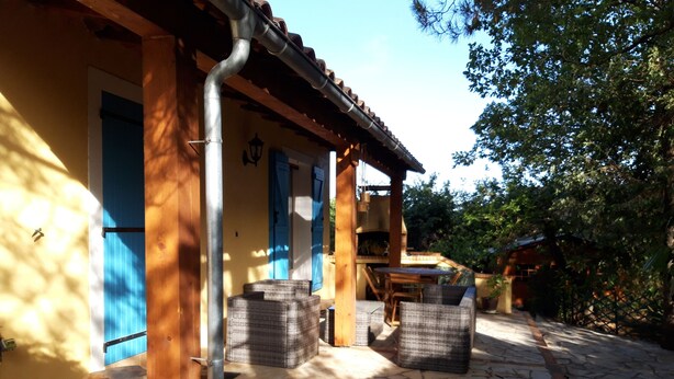 A rustic outdoor seating area with stone flooring and wooden furniture. - Villa Rénovée, à 5 Minutes du Centre et D'un Supermarché (Cogolin)