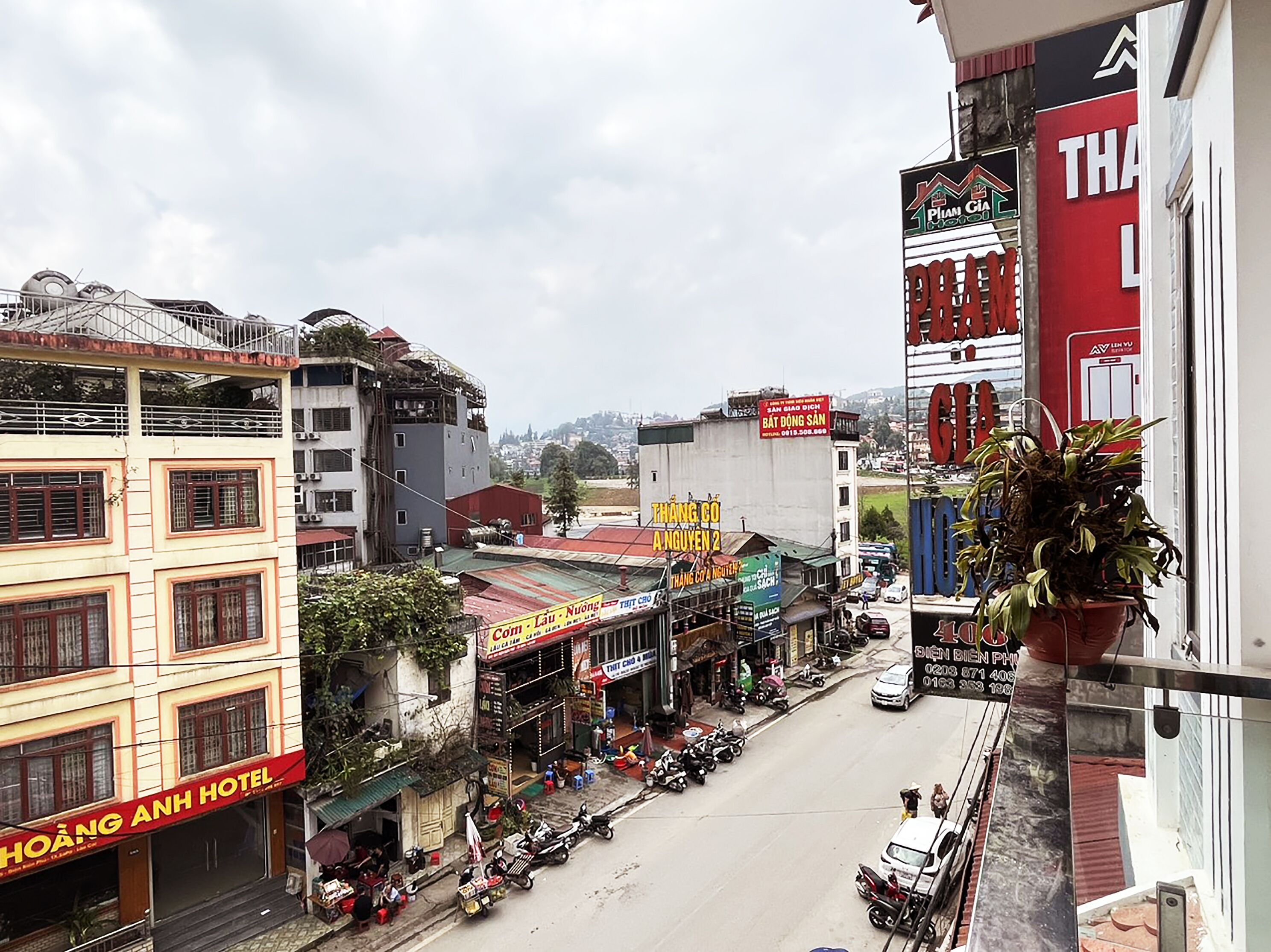 Vista de la calle con un hotel llamado 'Hoàng Anh Hotel' a la izquierda.