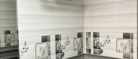 A modern bathroom with a white sink, toilet, and a towel rack above the sink.