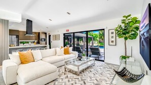 Una sala de estar moderna con un sofá, una mesa de centro y vistas al patio exterior.
