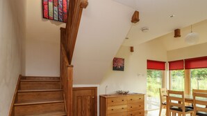 A wooden staircase leading to a dining area with a view of greenery outside. - Shepherds Rest (Fort William)