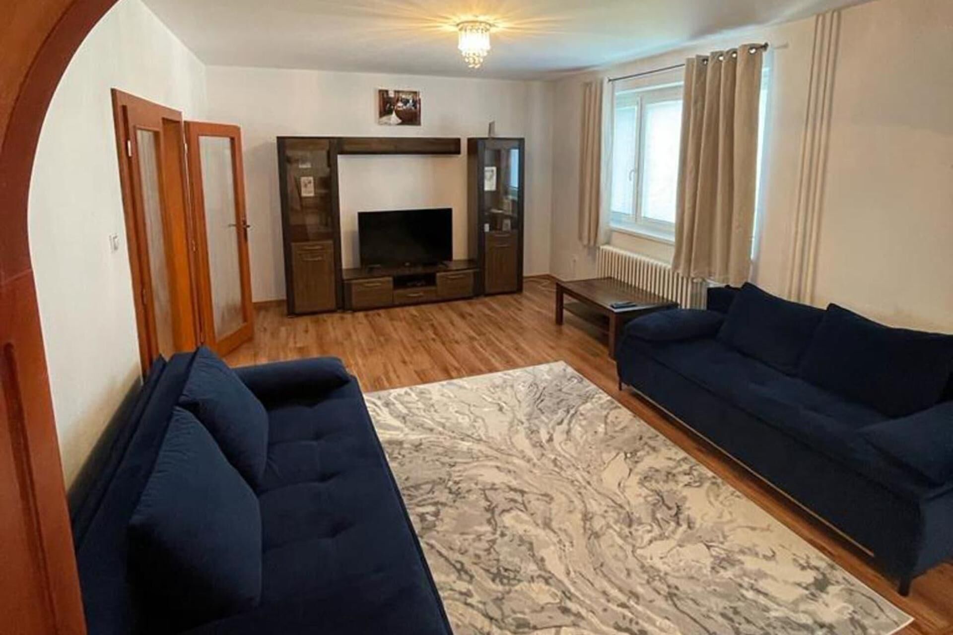 A living room with a sofa, a TV, and a fireplace.