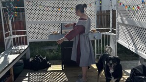 A covered outdoor area with a grill, a dog, and a person. - Welcome to our home. We speak English and mandarin if needed. (Kamloops)