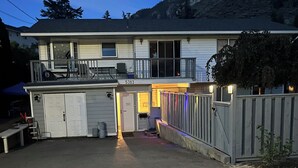 A two-story house with a garage, a balcony, and a mountain backdrop. - Welcome to our home. We speak English and mandarin if needed. (Kamloops)