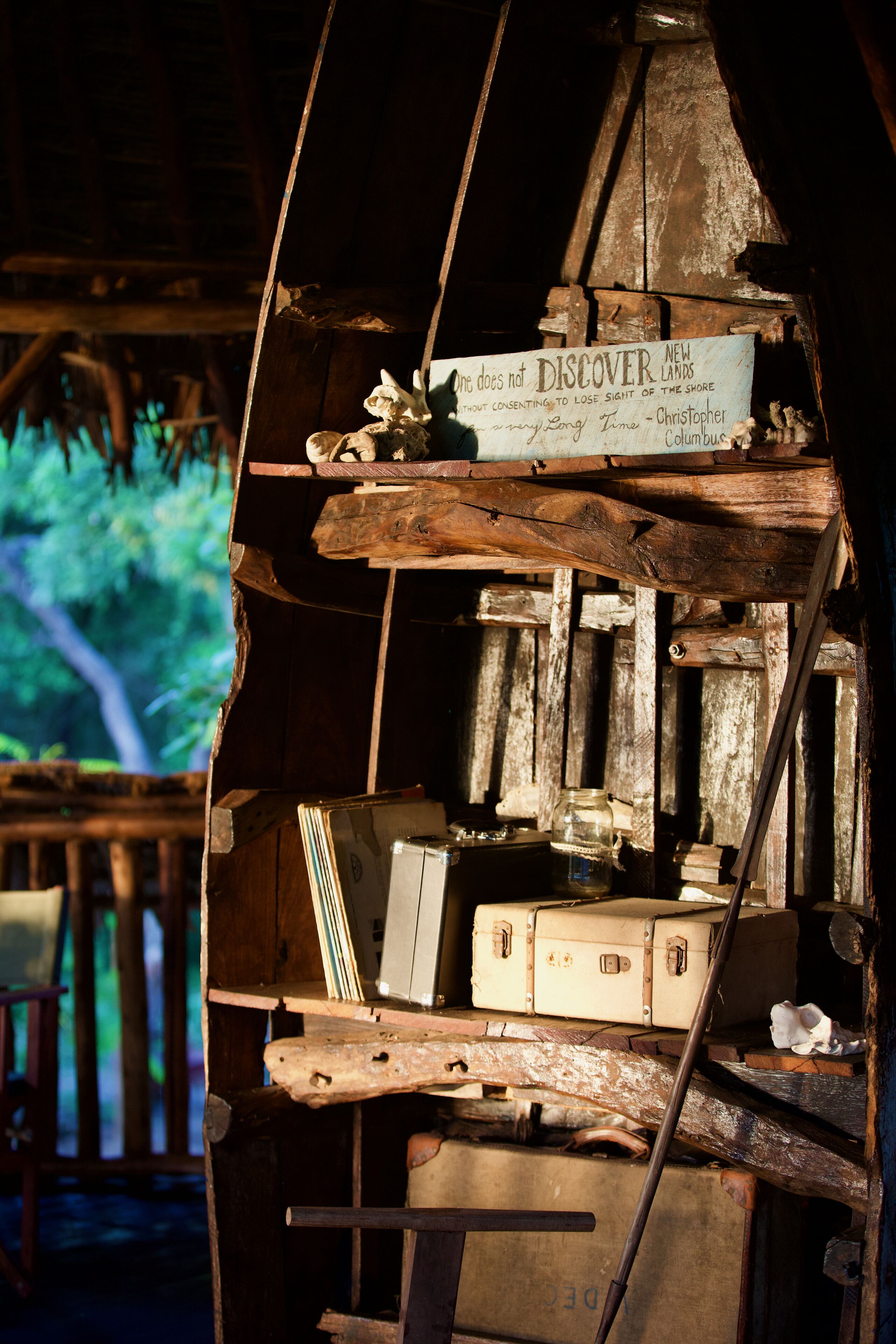 A rustic wooden structure with a sign that reads "New Lands without Consent to Lose Sight of the Shore."