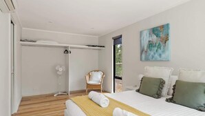 A bedroom with a bed, a chair, a fan, and a window. - Wren Studio - Private One-Bedroom Studio Nestled in Bushland (Yallingup)