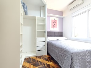 Une chambre à coucher avec un lit, une armoire et une fenêtre.