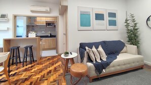 Ein modernes Wohnzimmer mit einer Couch, einem Couchtisch und einem Fischgrätparkettboden.