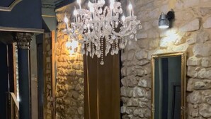 Una escalera con paredes de piedra y un candelabro.