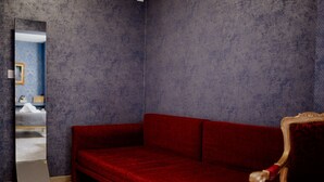 Una habitación con un sofá rojo, un espejo y una pared con diseño.