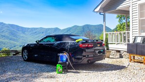A black convertible car parked on a gravel driveway with a house and mountains in the background. - Stunning Mountain Views with Hot Tub & 2 King Suites! Private & Peaceful. (Robbinsville)