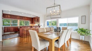 Une cuisine spacieuse dotée de meubles en bois, d’un îlot central et d’un coin repas avec une table et des chaises en bois.