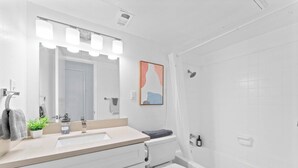 Une salle de bain avec un lavabo, des toilettes et une douche.