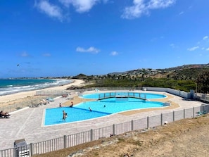 A swimming pool with a view of the beach and ocean.
