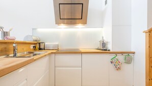 A modern kitchen with a stainless steel range hood, wooden countertop, white cabinetry, and a wooden floor. - Stunning 5-room duplex, 10 people, panoramic view, direct ski access, Avoriaz (Avoriaz)